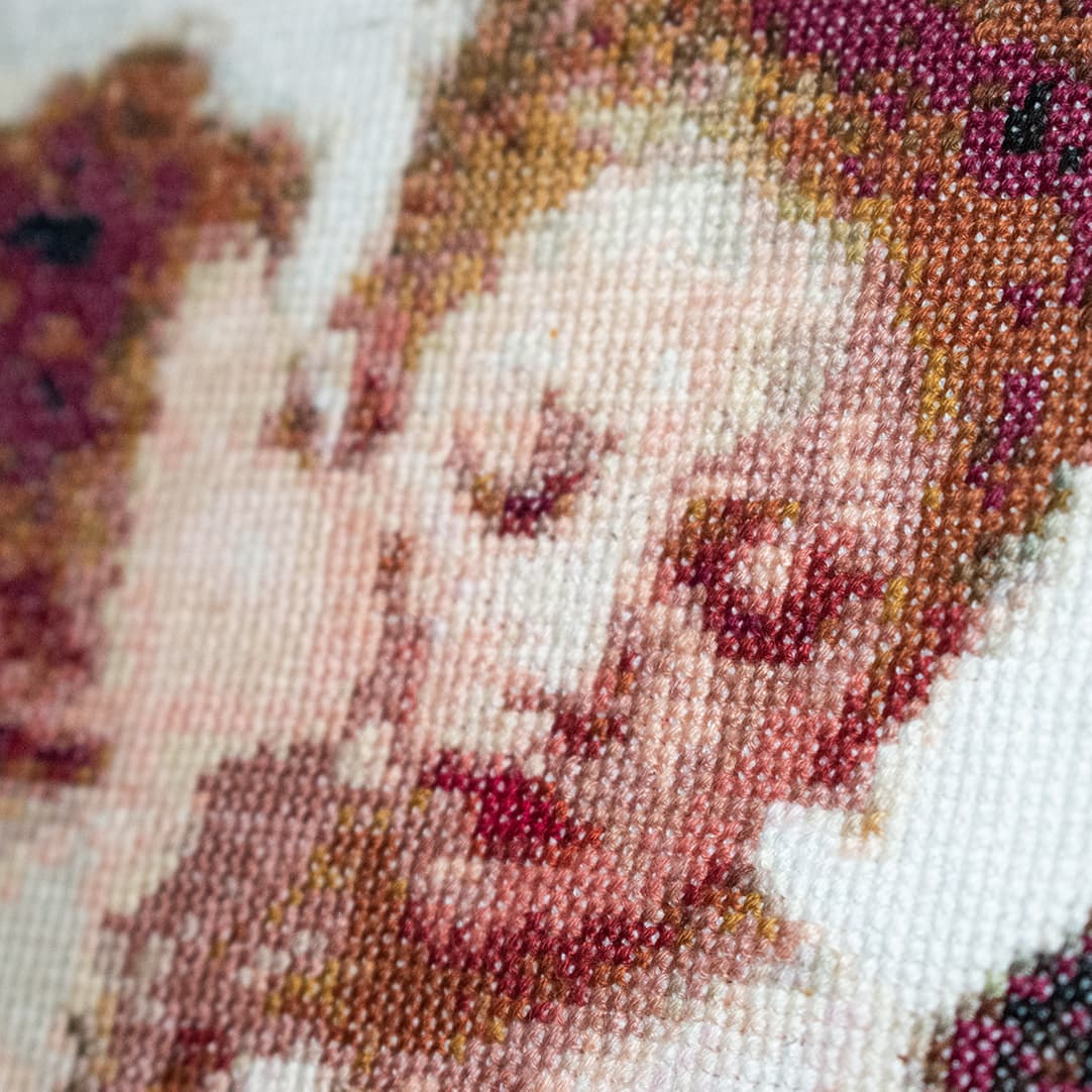 Close-up of “The First Kiss”: the angel’s face, stitched cross by cross