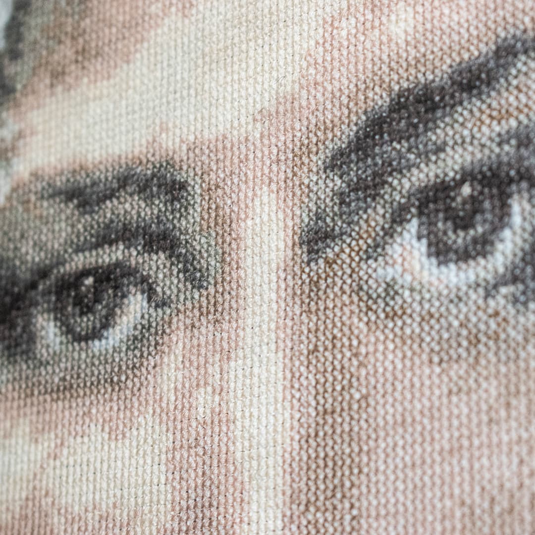 Close-up fragment of “The Face of Christ”: the texture of hand-stitched crosses