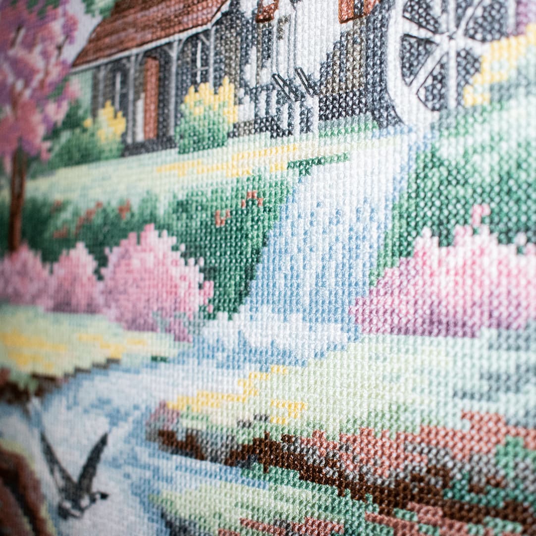 Close-up fragment of “A Quiet Paradise”: the texture of hand-stitched crosses