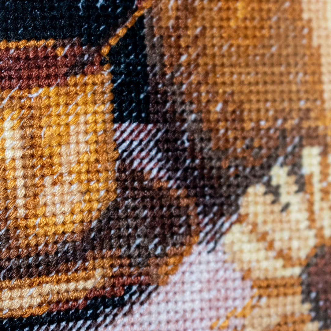 Close-up fragment of “Sunflowers and a Cup”: the texture of hand-stitched crosses
