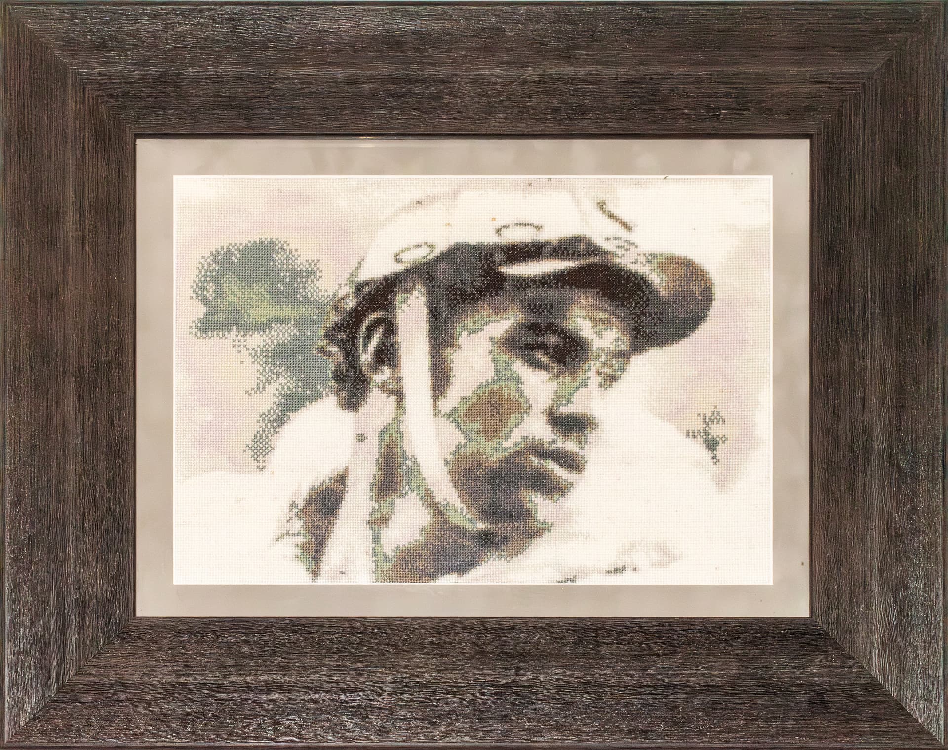 Monochrome embroidered portrait of a man in a cap, wide oak frame