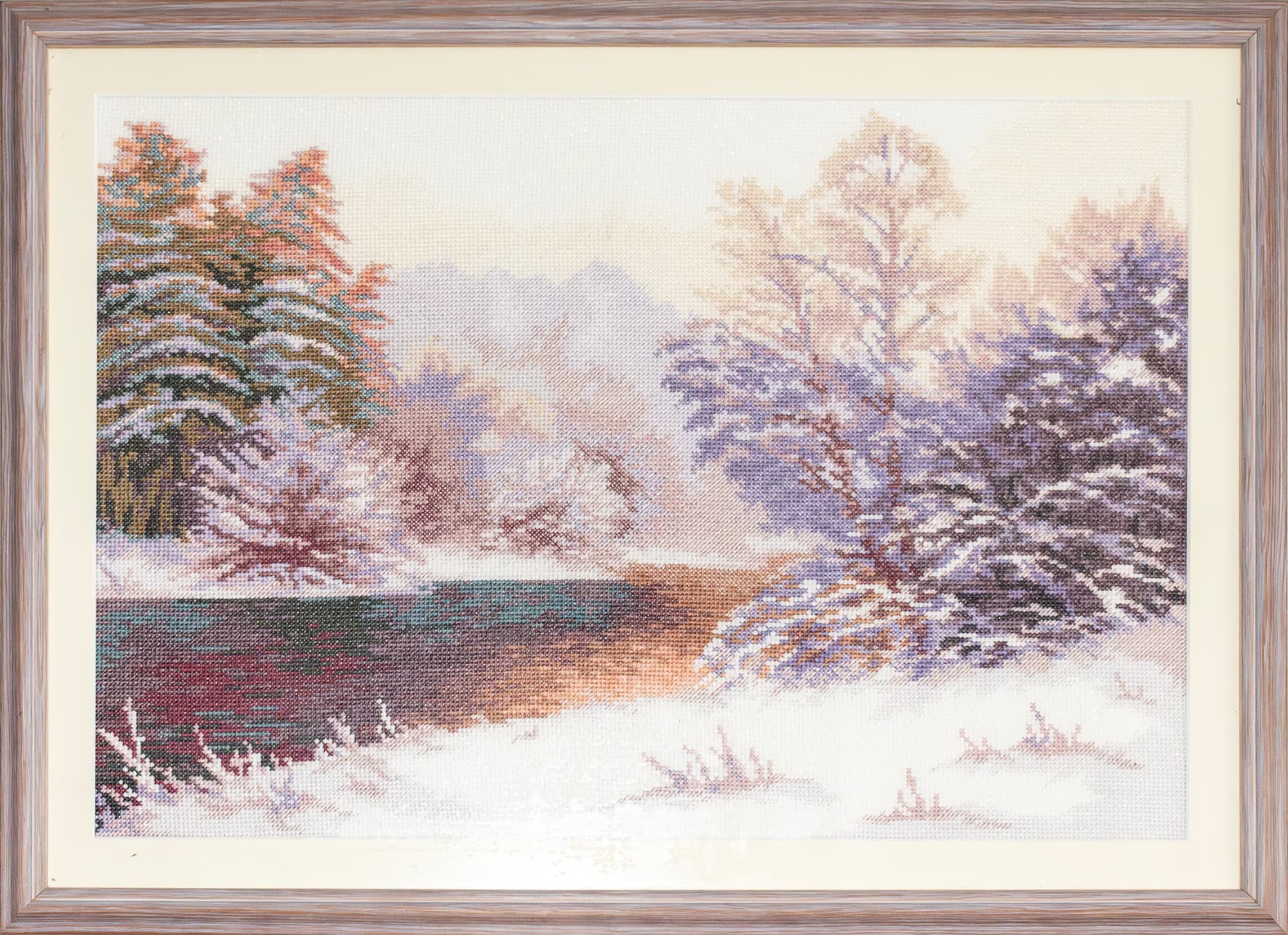 Embroidered winter river landscape in a pale frame